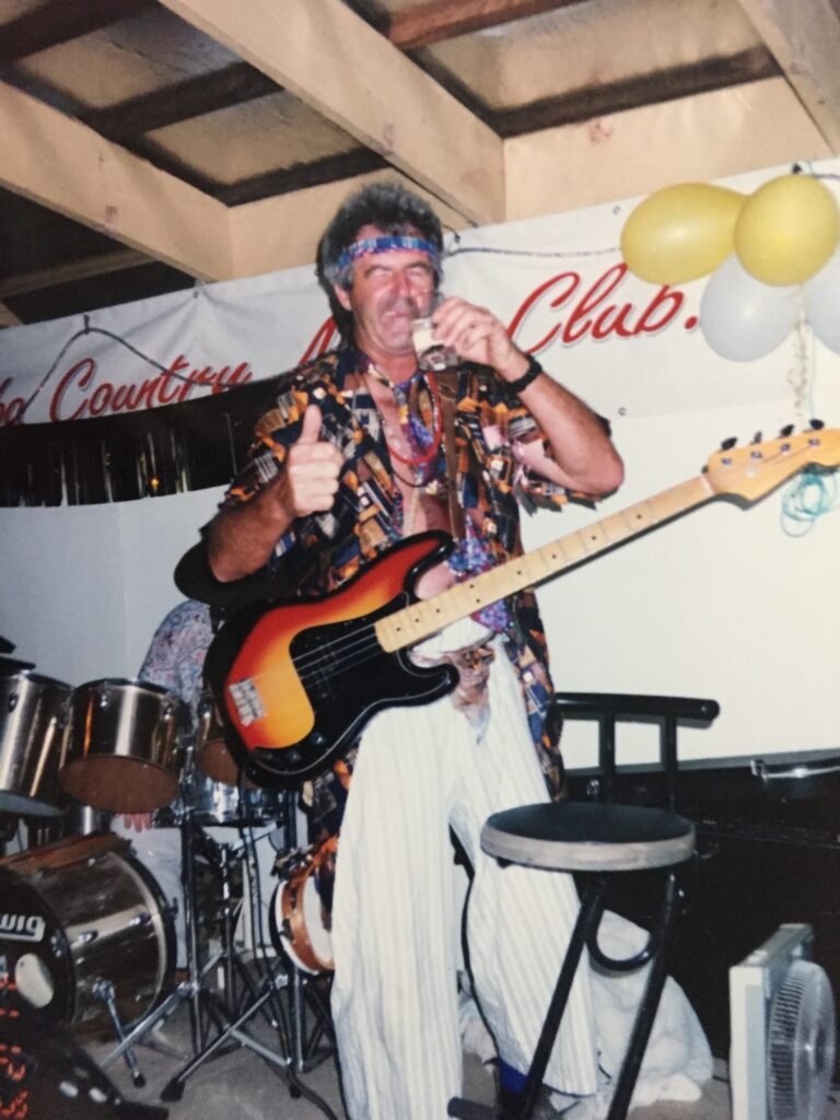 Mel's dad playing his favourite guitar at a fancy dress country music event